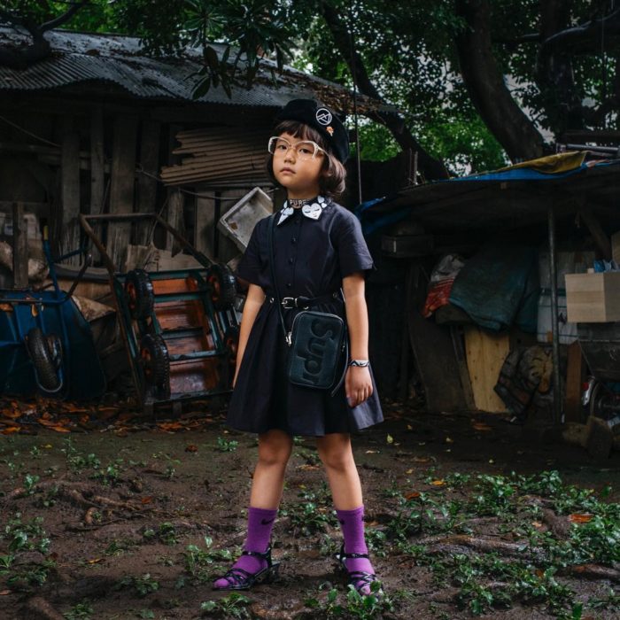 Niña llamada coco vistiendo vestido negro y gafas 