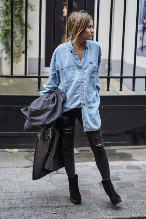 Chica usando una blusa de mezclilla con jeans rasgados 
