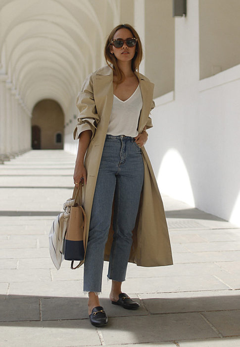 Chica usando mocasines con gabardina jeans de tiro alto y blusa blanca 