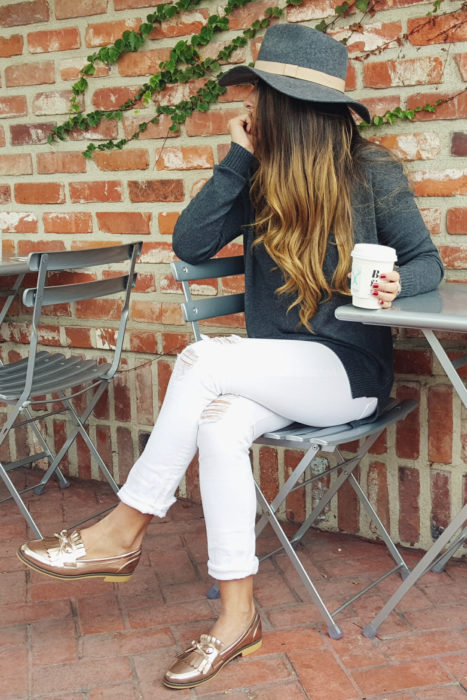 Chica usando mocasines con pantalón blanco y cardigan gris 