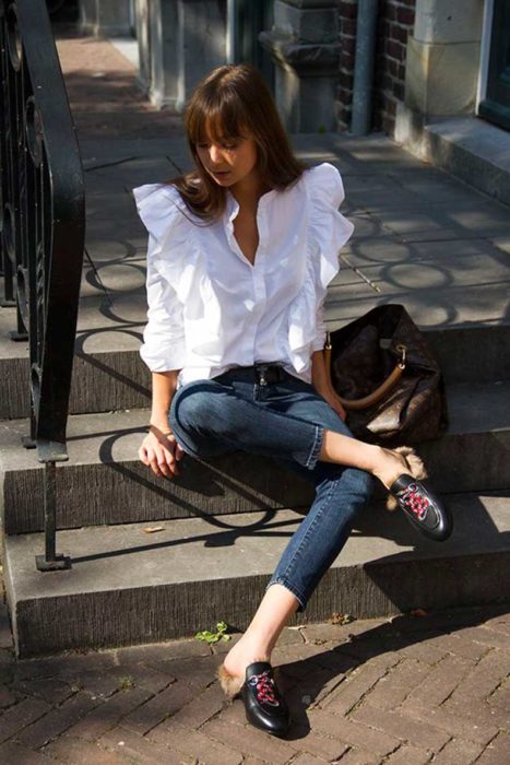 Chica usando mocasines con jeans y blusa blanca 