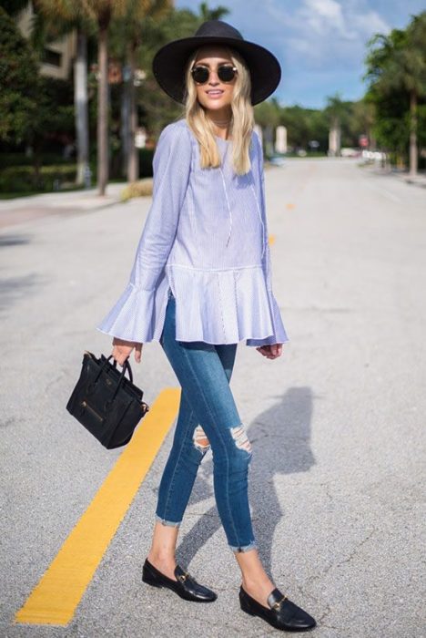 Chica usando mocasines con jeans rasgados y bluson azul marino 