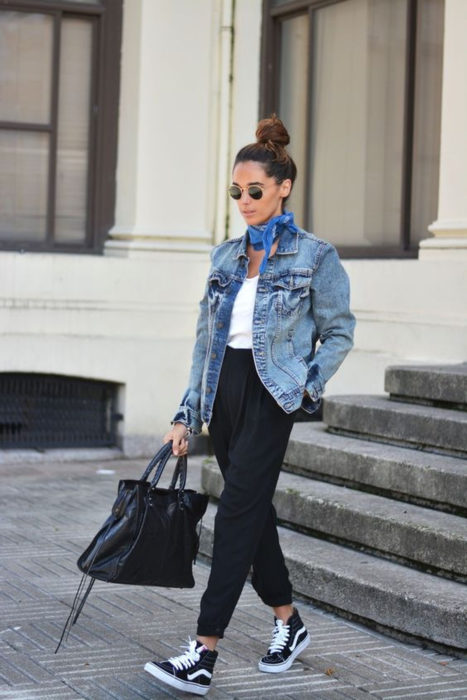 Chica usando pantalones negros con tenis blusa blanca y chaqueta de mezclilla 