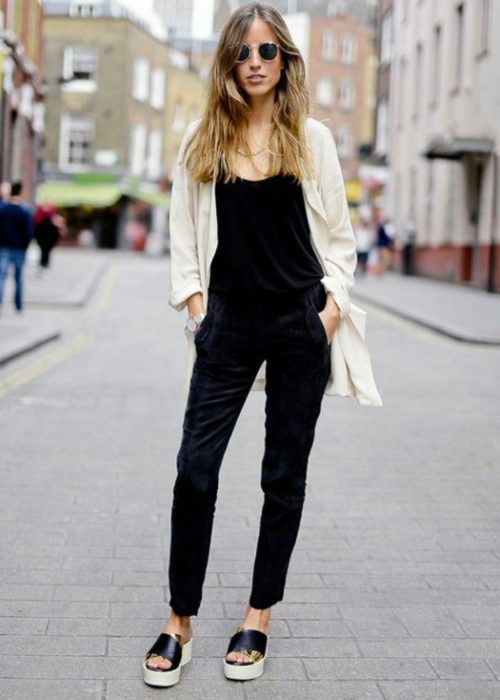 Chica usando un outfit de color negro con un blazer e tonos claros 