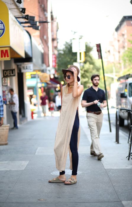 Chica usando una maxiblusa sombrero jeans y sandalias 