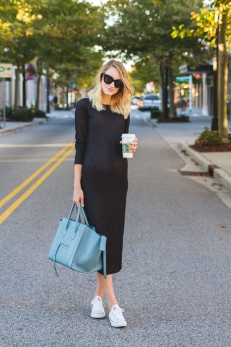 Chica usando un vestido middi bolso acul y tenis blancos 