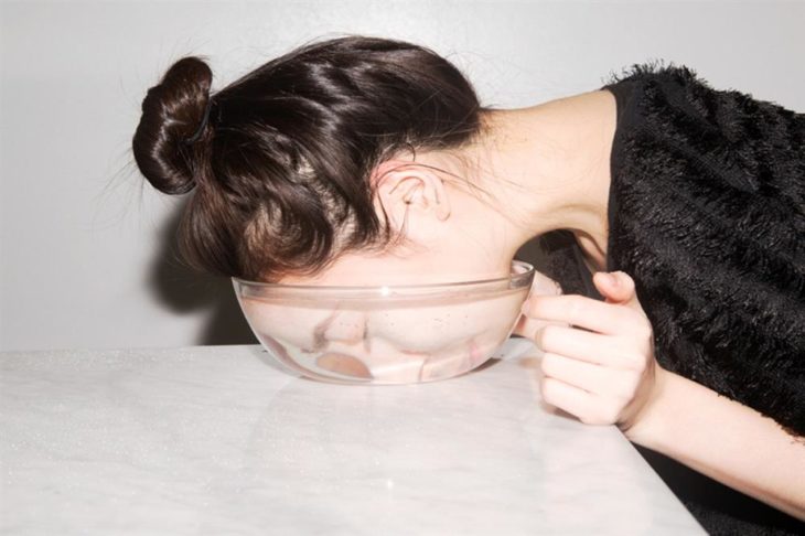 chica sumergiendo el rostro en agua