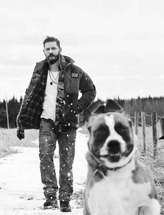 chico paseando con su perro en la nieve 