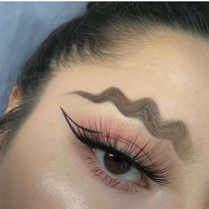 Chica con sus cejas maquilladas en formas de ondas 