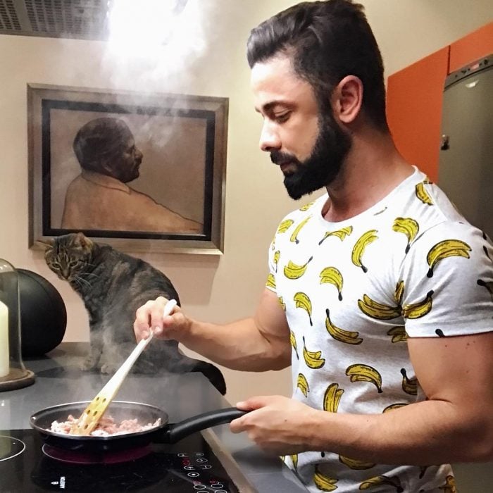 chico cocinando junto a su gato 