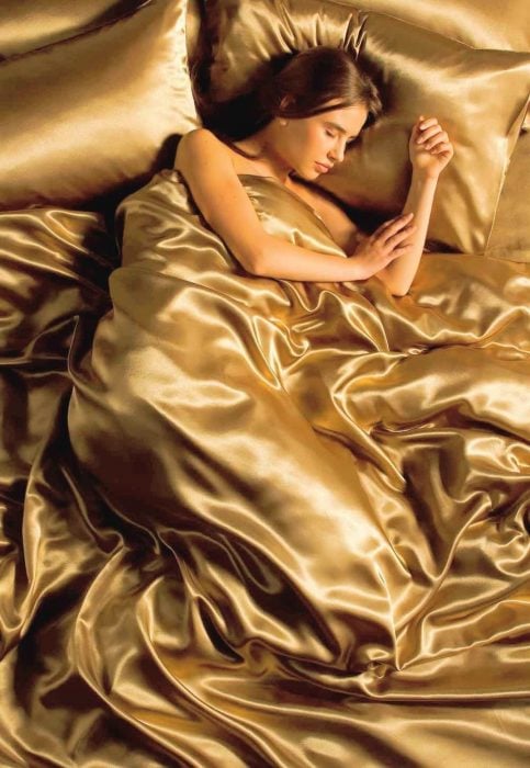Chica durmiendo en sabanas de seda 