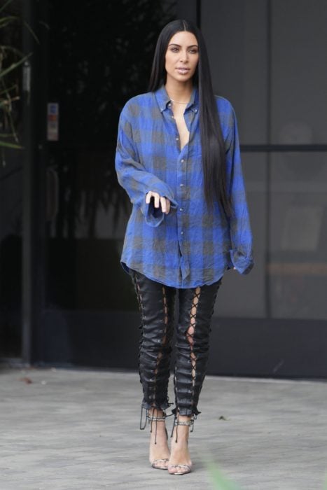 Kim Kardashian usando una camisa de leñador y pantalones negros 
