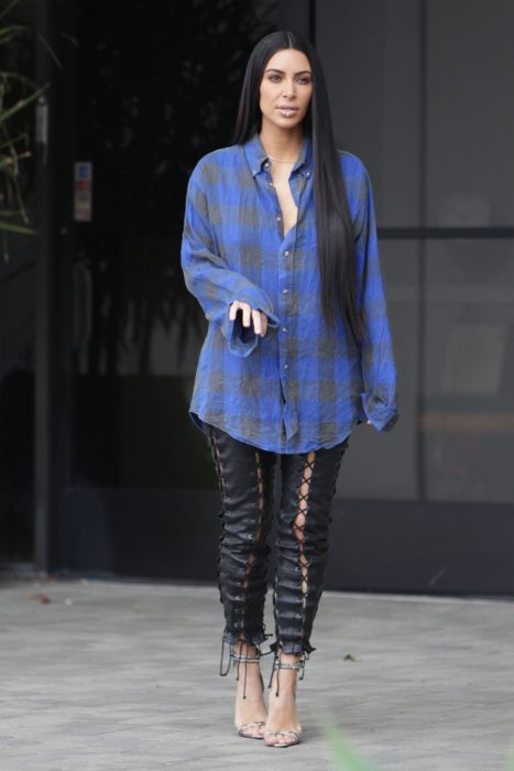 Kim Kardashian usando una camisa de leñador y pantalones negros 