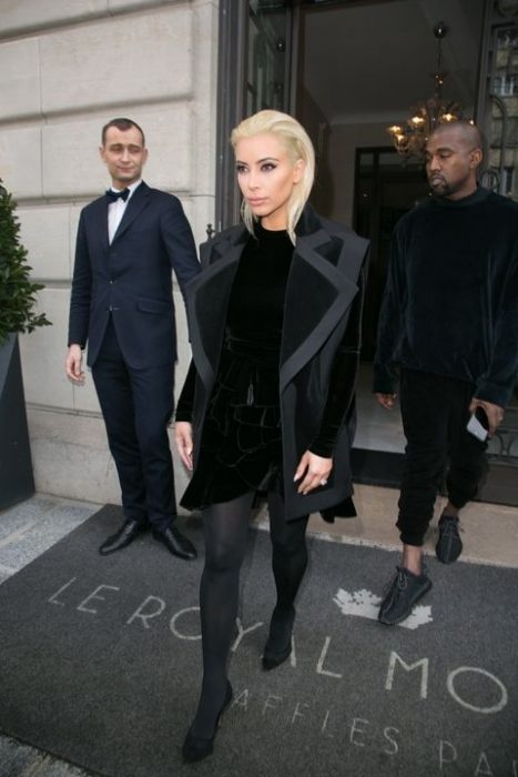 Kim kardashian usando un traje y abrigo de color negro 