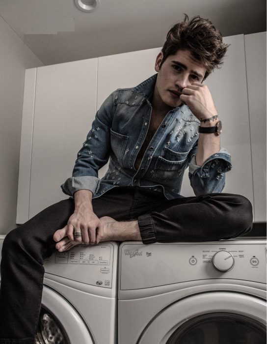 chico sentado en una lavadora 