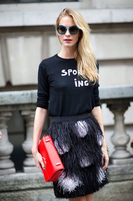 Chica usando una falda de plumas y una blusa en color negro 