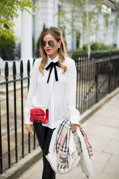 Chica usando una blusa con un lazo negro atado al cuello 