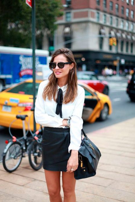 Chica usando una blusa con un lazo negro atado al cuello 