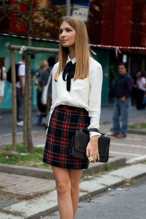 Chica usando una blusa con un lazo negro atado al cuello 