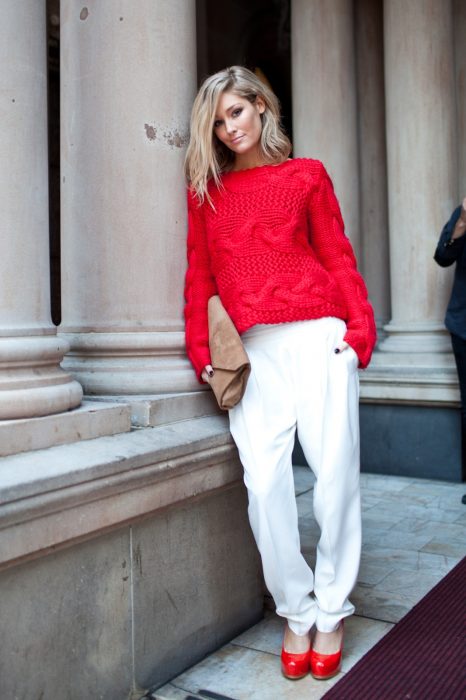 Chica usando un pantalón blanco, suéter rojo y zapatos rojos 