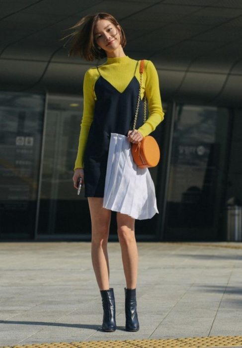 Chica usando un vestido de tirantes con una blusa de cuello de tortuga abajo