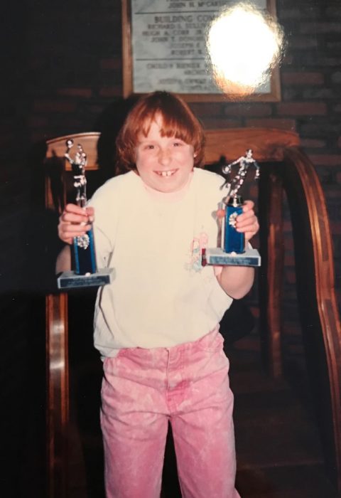 niña sosteniendo un trofeo