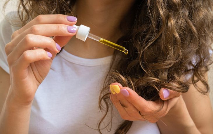 chica aplicando aceite en el cabello