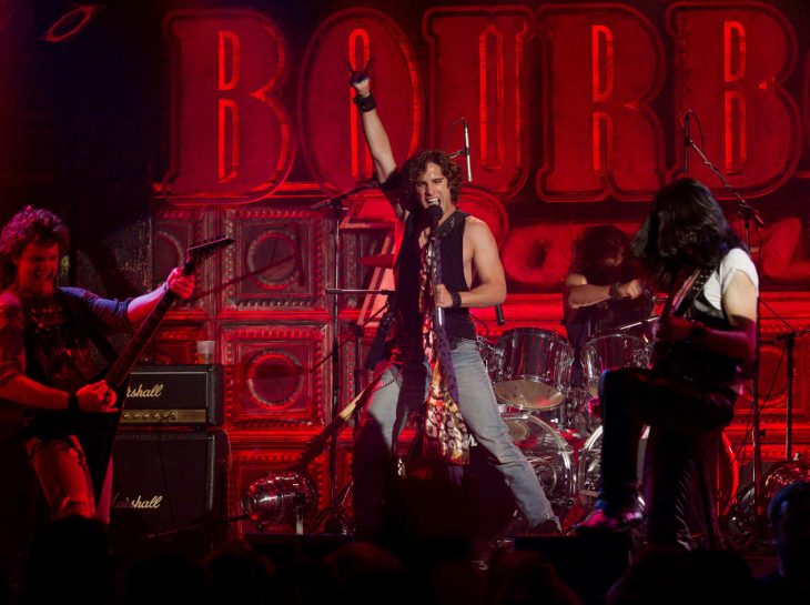 hombre cantando con banda de rock 