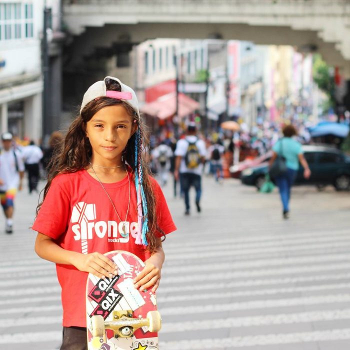 niña con gorra y patineta 