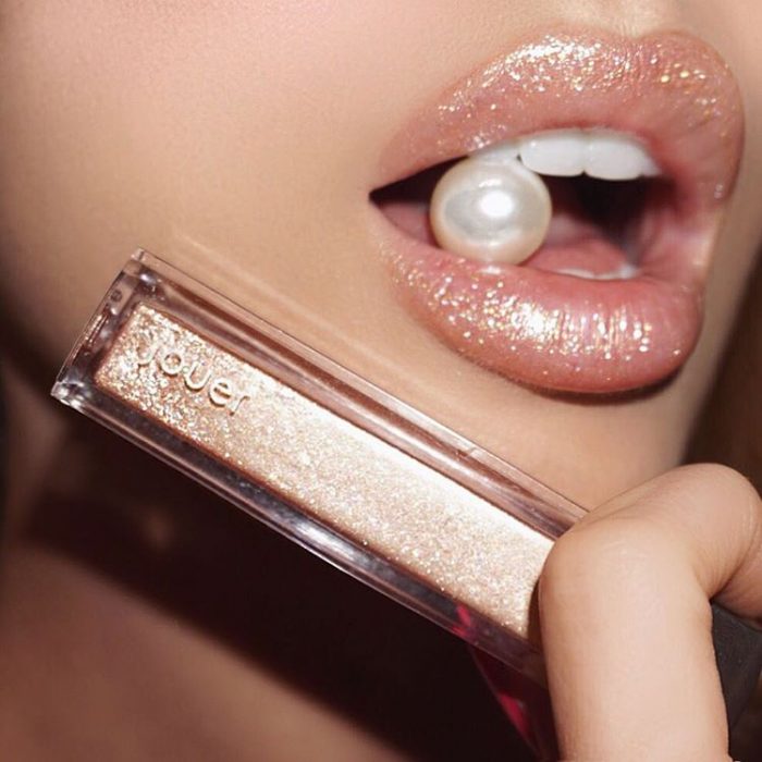 Chica usando un gloss con glitter 