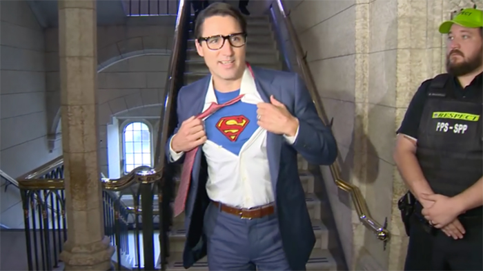 Justin Trudeau abriendo su camisa para revelar a superman 
