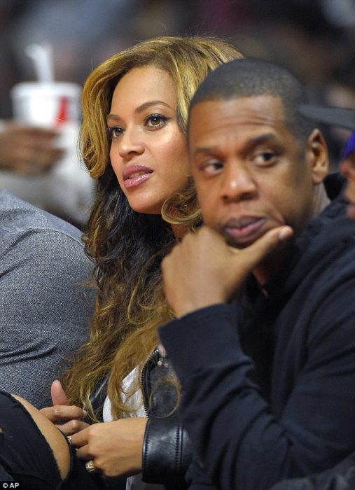 Jay z y Beyoncé sentados durante un juego de basketball