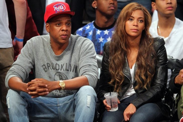 Jay z y Beyoncé sentados durante un juego de basketball