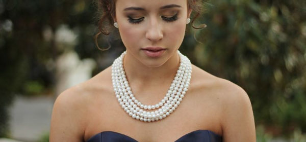 chica usando un collar de perlas 