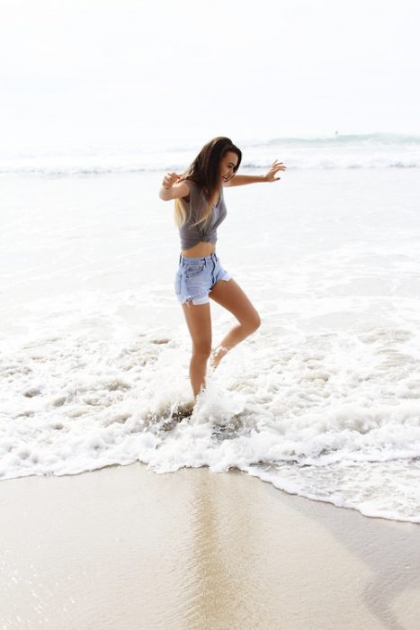 Chica bailando en la playa 