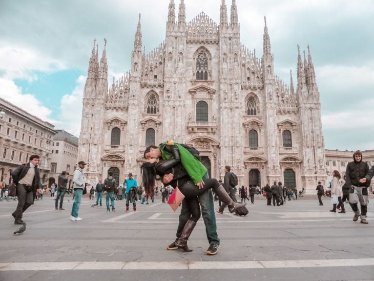 Pareja tomandose una foto en medio de una plasa de Milán, Italia 