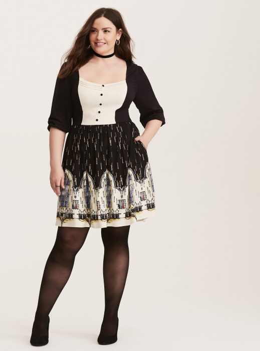 Chica plus size usando un vestido negro con estampados de Harry Potter 