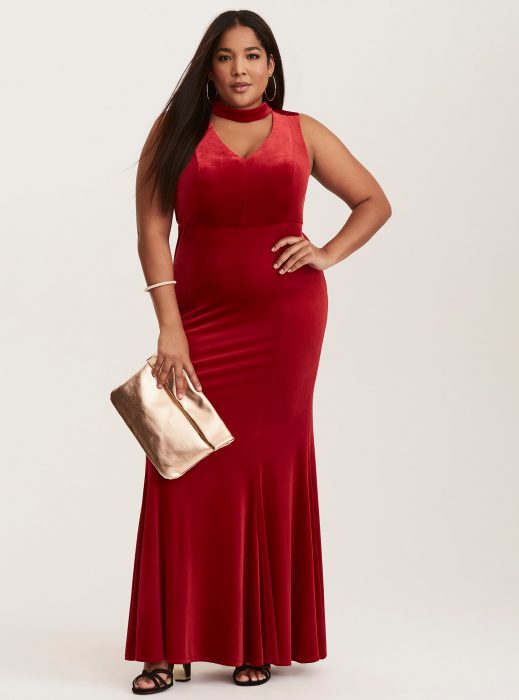 Chica plus size usando un vestido rojo de terciopelo con una gargantilla 