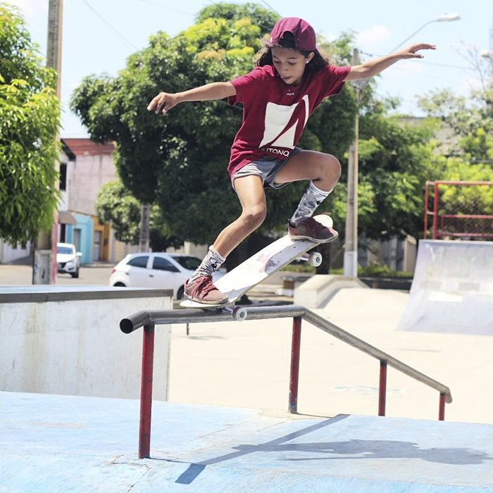 niña con patineta subiendo riel 