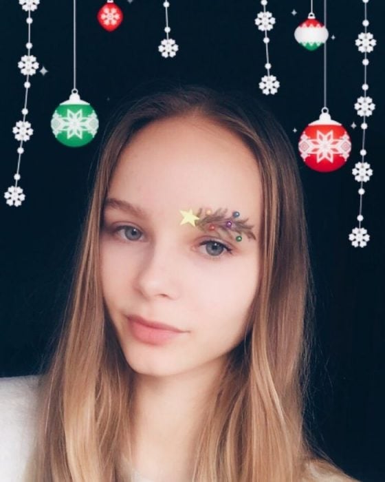 Chica con las cejas despeinadas y con decoraciones como si se tratara de un árbol de navidad 