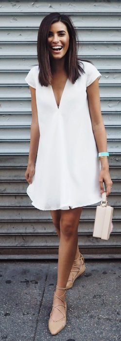 Chica usando un vestido blanco con flats de color cameo