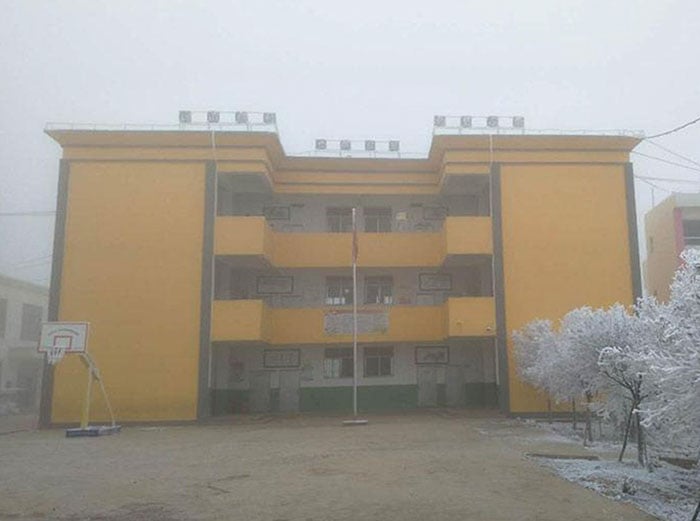 Escuela del niño que camina en la nieve para llegar a la escuela 