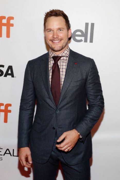 Chris Pratt sonriendo mientras usa un traje 