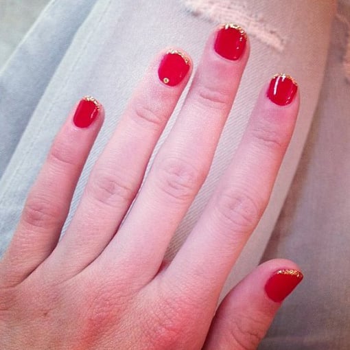 Uñas de Emma Roberts con diseño en color rojo y toques de dorado 