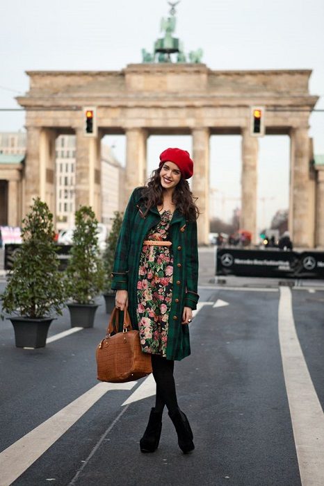 Chica con boina roja vestido de flores abrigo verde medias y botas negras