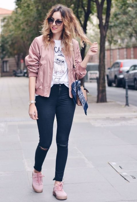 chica usando mezclilla, blusa estampada, tenis y chamarra rosa