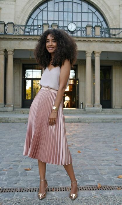 falda tableada rosa metalica, blusa de tejido ligero, chica cabello rizado