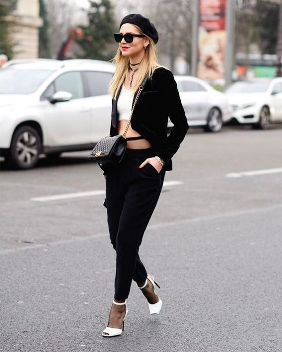 chica con pantalones y blazer negro croptop blanco zapatillas blancas y boina negra