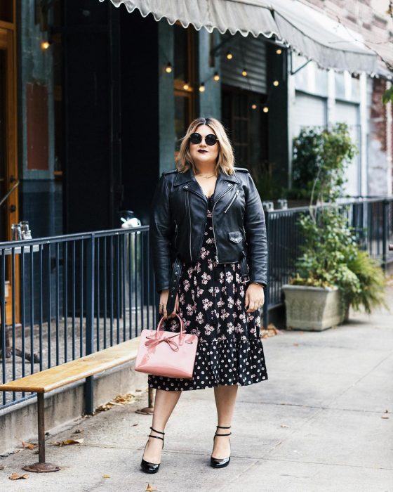 chica chubby con vestido negro con flores y bolso rosa pastel 