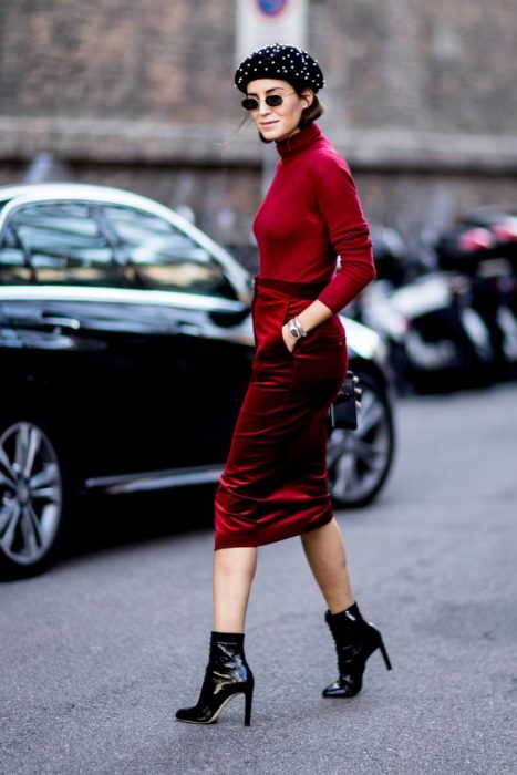 chica con falda lapiz de terciopelo rojo blusa cuello de tortuga roja boina negra botas de charol